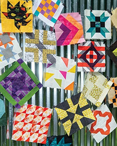 Colorful quilt blocks displayed on a corrugated metal surface.