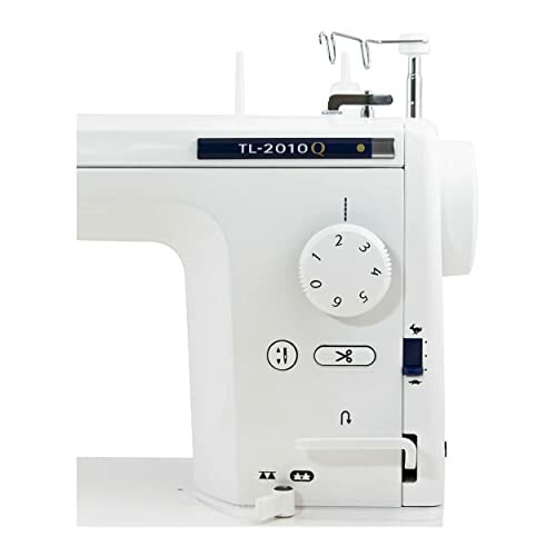 White sewing machine with control dial and thread holder